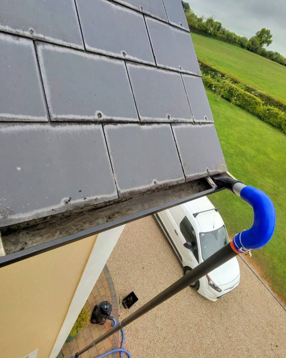Gutter camera view of vacuum clearing the gutter at roof level